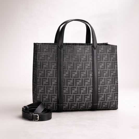 Black patterned tote bag with matching belt on a light gray background